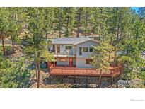Exterior view of the home's expansive deck nestled among the trees at 398 Fred Rd, Boulder, CO 80302
