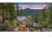 Charming mountain home with a spacious deck and stunning views of the surrounding forest and mountain range at 398 Fred Rd, Boulder, CO 80302