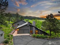 Stunning mountain home with a two-car garage, stone chimney and beautiful sunset views at 8664 Middle Fork Rd, Boulder, CO 80302