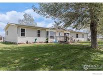 Charming single-story home boasts a well-maintained lawn and inviting front porch at 10635 County Road 24, Fort Lupton, CO 80621