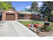 Charming brick home featuring an inviting front porch and well-manicured lawn at 1234 S Holland Ct, Lakewood, CO 80232