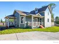 Charming two-story home featuring a covered porch, freshly painted siding, and well-manicured lawn at 1711 Antero Dr, Longmont, CO 80504