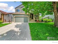 Charming two-story home featuring a well-manicured lawn, front porch, and attached two-car garage at 2335 Dogwood Cir, Louisville, CO 80027