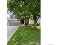Charming two-story home with a well-manicured lawn and mature trees offering shade at 2335 Dogwood Cir, Louisville, CO 80027