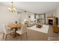 Bright living room with dining area features a cozy fireplace and access to a private balcony at 316 Wright St # 203, Lakewood, CO 80228
