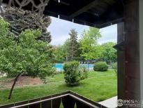 Relaxing view from the patio overlooking the lush green lawn and community pool in this beautiful home setting at 3250 Oneal Cir # 14, Boulder, CO 80301