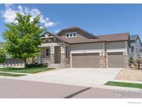 Charming two-story home with a well-manicured lawn and three-car garage at 4631 Lakeside Dr, Firestone, CO 80504