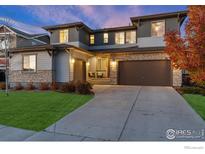 Beautiful two-story home with a two car garage, stone accents, and manicured lawn at 515 Orion Ave, Erie, CO 80516