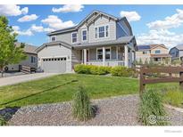 Charming two-story home featuring a well-manicured lawn and inviting front porch at 759 Old Wagon Trail Cir, Lafayette, CO 80026