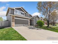 Charming two-story home with a well-manicured lawn and attached two-car garage at 9930 Cascade St, Firestone, CO 80504