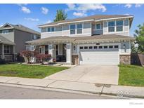 Charming two-story home features a well-manicured lawn and an attached two-car garage at 14049 Detroit Dr, Thornton, CO 80602