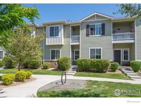Inviting two-story townhome with manicured front yard landscaping, steps, and walkway leading to the entrance at 1426 Sepia Ave, Longmont, CO 80501