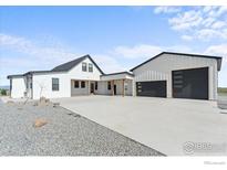 Stunning modern farmhouse with white siding, black trim, and spacious driveway at 14407 County Road 18 1/2 Rd, Fort Lupton, CO 80621