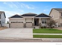 Charming home featuring a three car garage, a well maintained lawn, and stone accents at 2200 Cadman St, Berthoud, CO 80513