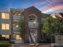 Charming multi-level condo building with brick accents, exterior stairs, and balcony under the beautiful evening sky at 33 S Boulder Cir # 316, Boulder, CO 80303