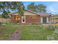 Charming brick home with a well-lit front entrance and partial landscaped garden at 437 Fox St, Longmont, CO 80504