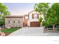 Charming two-story home featuring stone accents, a spacious driveway, and a well-manicured front yard at 609 Corona Ct, Lafayette, CO 80026