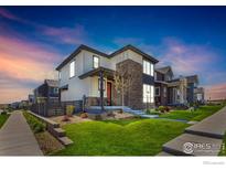 Charming two-story home with landscaped yard and inviting front porch at 6211 Stable View St, Castle Pines, CO 80108