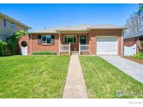 Charming brick home with a well-manicured lawn, white picket fence, and inviting front porch at 729 Elm St, Denver, CO 80220