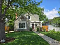 Charming home featuring a well-manicured front yard, mature trees, and a welcoming walkway at 731 Bowen St, Longmont, CO 80501