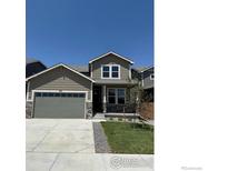 Charming two-story home with a well-manicured lawn and a two-car garage at 793 Griffith St, Lochbuie, CO 80603