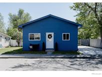 Charming blue single-story home with a well-maintained front yard and a driveway on the side at 934 6Th St, Berthoud, CO 80513