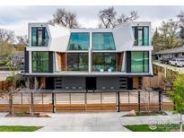 Modern home featuring a sleek white exterior, expansive windows, and a stylish wood fence at 944 Arapahoe Ave # A, Boulder, CO 80302