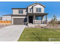 Charming two-story home features a well-kept lawn, covered porch, and attached two-car garage at 9882 Cathay St, Commerce City, CO 80022