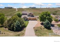 Beautiful home featuring a three-car garage, mature trees, and an extensive driveway at 10970 E 150Th Pl, Brighton, CO 80602