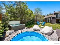 Landscaped backyard boasts a hot tub, stock tank pool and lounging area with mature trees at 1350 Lehigh St, Boulder, CO 80305