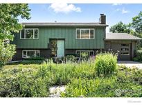 Two story home featuring green siding, updated windows and a lovely garden in the front yard at 1350 Lehigh St, Boulder, CO 80305