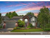 Charming two-story home with brick accents, mature trees, landscaped lawn and a two-car garage at 1401 Clover Creek Dr, Longmont, CO 80503