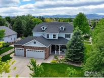 Charming two-story home boasts a three-car garage, covered porch, and beautiful landscaping with mountain views at 14675 Golden Eagle Run, Broomfield, CO 80023