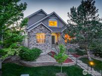 Charming two-story home with stone accents, mature trees, and well-maintained landscaping at 1613 Golden Bear Dr, Longmont, CO 80504