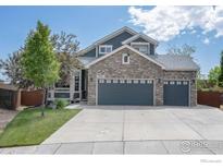 Charming two-story home with brick and siding exterior, a well-manicured lawn, and a two car garage at 2085 Tundra Cir, Erie, CO 80516