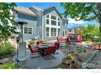 Well-landscaped backyard patio featuring an outdoor dining area and multiple seating areas at 23570 E Holly Hills Way, Parker, CO 80138