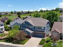 Beautiful two-story blue home with a well-maintained lawn and mature trees in a desirable neighborhood at 23570 E Holly Hills Way, Parker, CO 80138