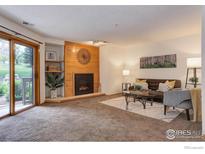 Inviting living room with a cozy fireplace and sliding door access to the outdoors at 2800 Sundown Ln # 109, Boulder, CO 80303