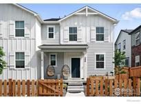 Charming two-story home with light grey siding, a cozy porch, and a well-maintained wooden fence at 308 Fickel Farm Trl, Berthoud, CO 80513