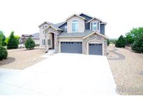 Charming two-story home with a two-car garage and stone accents around the entry and garage doors at 3106 Megan Way, Berthoud, CO 80513