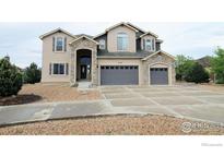 Charming two-story home featuring a stone entryway and a three-car garage at 3106 Megan Way, Berthoud, CO 80513