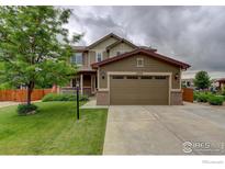 Inviting two-story home showcasing a well-manicured lawn and a spacious two-car garage at 6356 Twilight Ave, Firestone, CO 80504