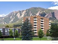 Brick apartment building features balconies with mountain views and a lush green lawn at 850 20Th St # 203, Boulder, CO 80302