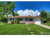 Charming single-story home boasts a brick facade and lush lawn with stone walkway to the front door at 855 33Rd St, Boulder, CO 80303