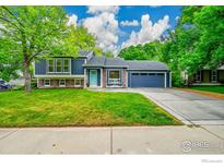 Charming blue two-story home with well-manicured lawn and a cozy front sitting area at 106 S Madison Ave, Louisville, CO 80027