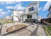 Charming two-story home with stone accents and a well-maintained front yard at 1099 Spartan Ave, Berthoud, CO 80513