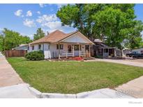 Charming home with inviting porch, beautiful lawn, mature tree, and pleasant curb appeal at 1101 Spruce St, Louisville, CO 80027