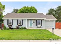 Charming home featuring a well-manicured lawn, flower boxes under the windows, and a cozy bench on the porch at 13441 Sheridan Blvd, Broomfield, CO 80020