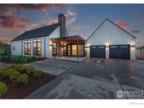 Modern home featuring a covered front entry, a stone chimney, two car garage and professionally landscaped front yard at 1563 Spring Creek Xing, Lafayette, CO 80026