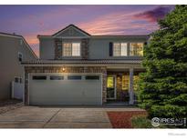 Charming two-story home featuring stone accents, a spacious garage, and a well-manicured yard at 18656 Kelly Pl, Denver, CO 80249